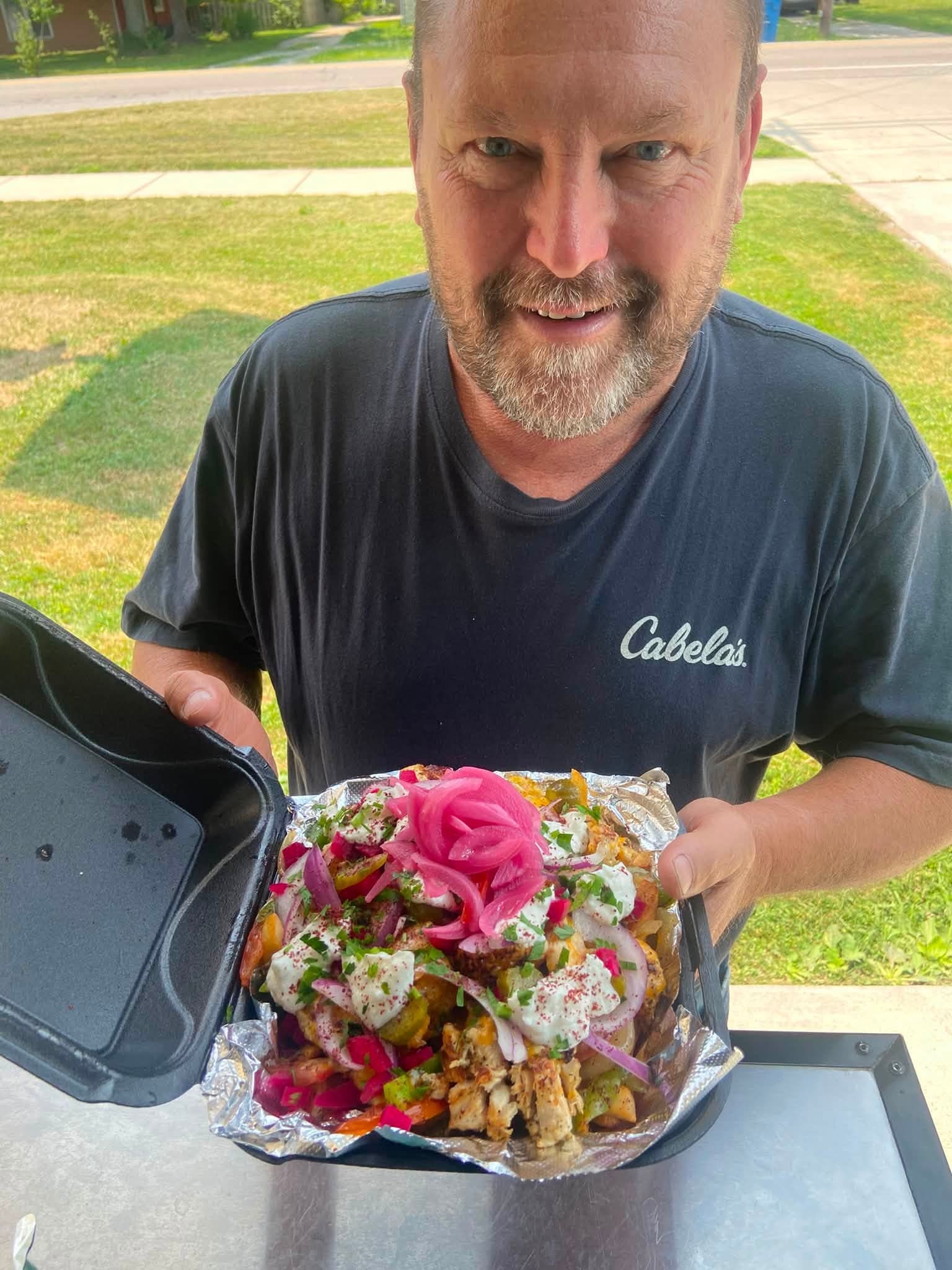 Loaded chicken shawarma fries piled with pickled onion, sumac and garlic sauce